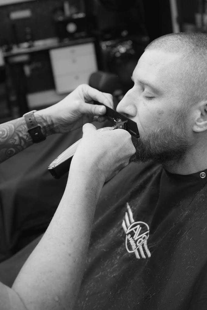 Man receiving beard trim at a barbershop.